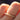 Gold ring with small diamonds on a finger against a blurred background