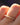 Gold ring with small diamonds on a finger against a blurred background